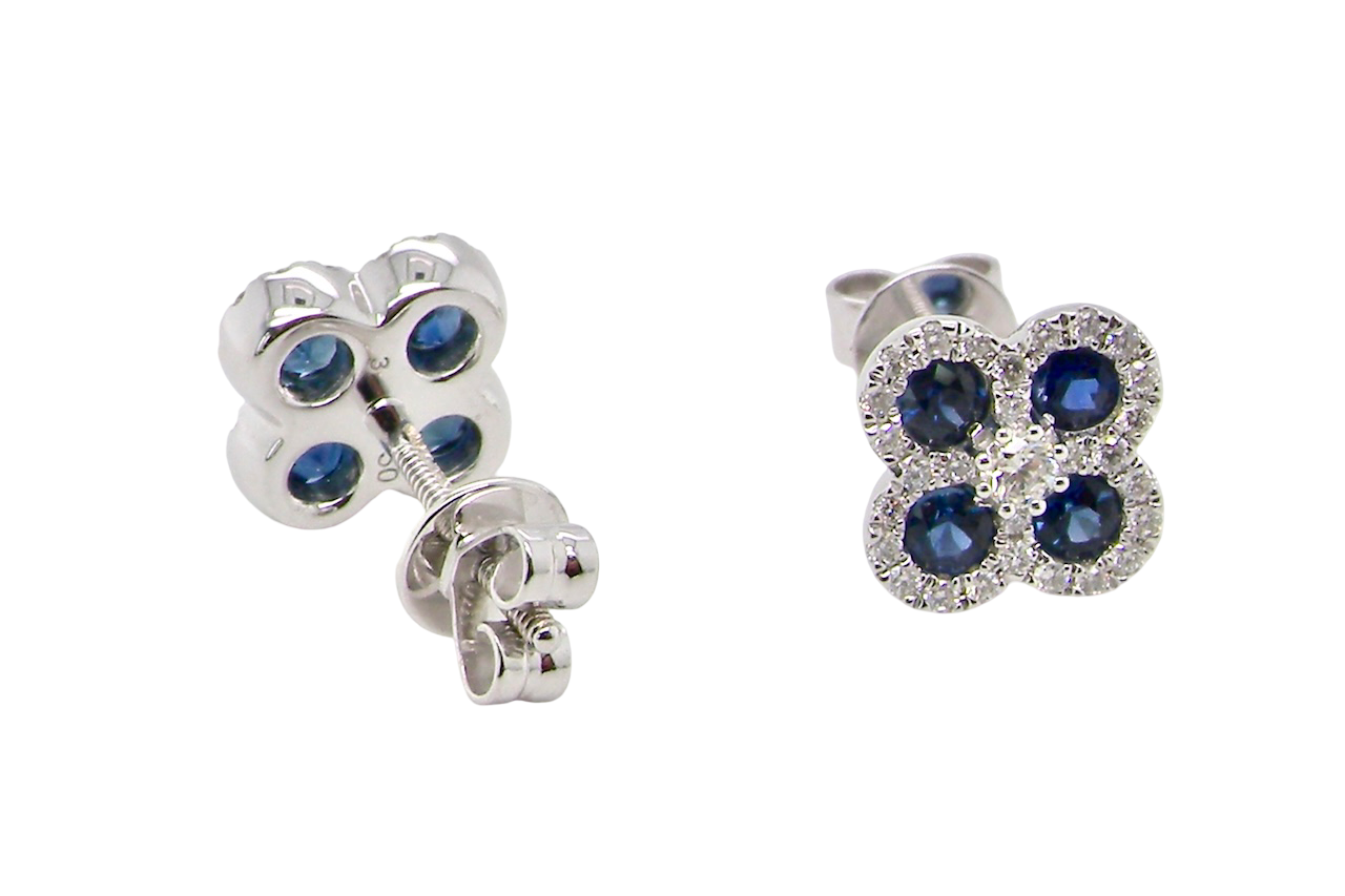 Pair of silver earrings with blue gemstones on a white background