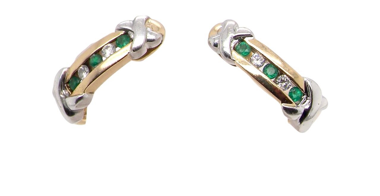 A pair of earrings, half hoop style. The centre a channel set vertical row of emeralds and diamonds,