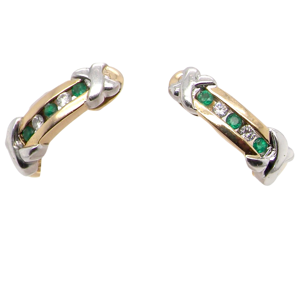 A pair of earrings, half hoop style. The centre a channel set vertical row of emeralds and diamonds,