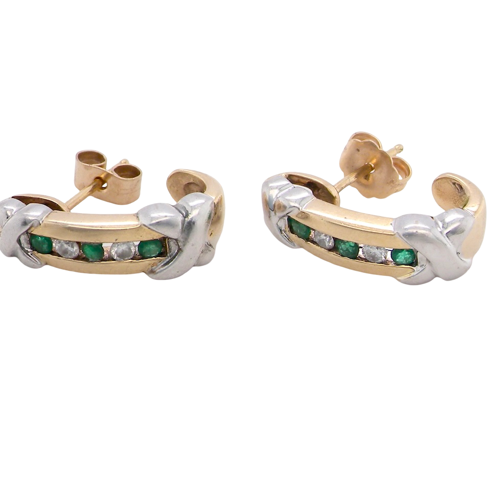 A pair of earrings, half hoop style. The centre a channel set with emeralds and diamonds,