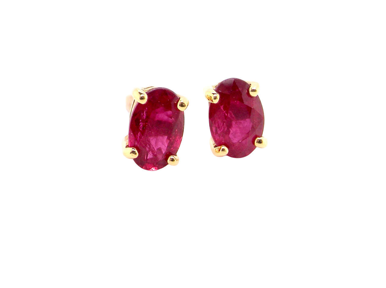 Pair of ruby earrings with gold settings on a white background