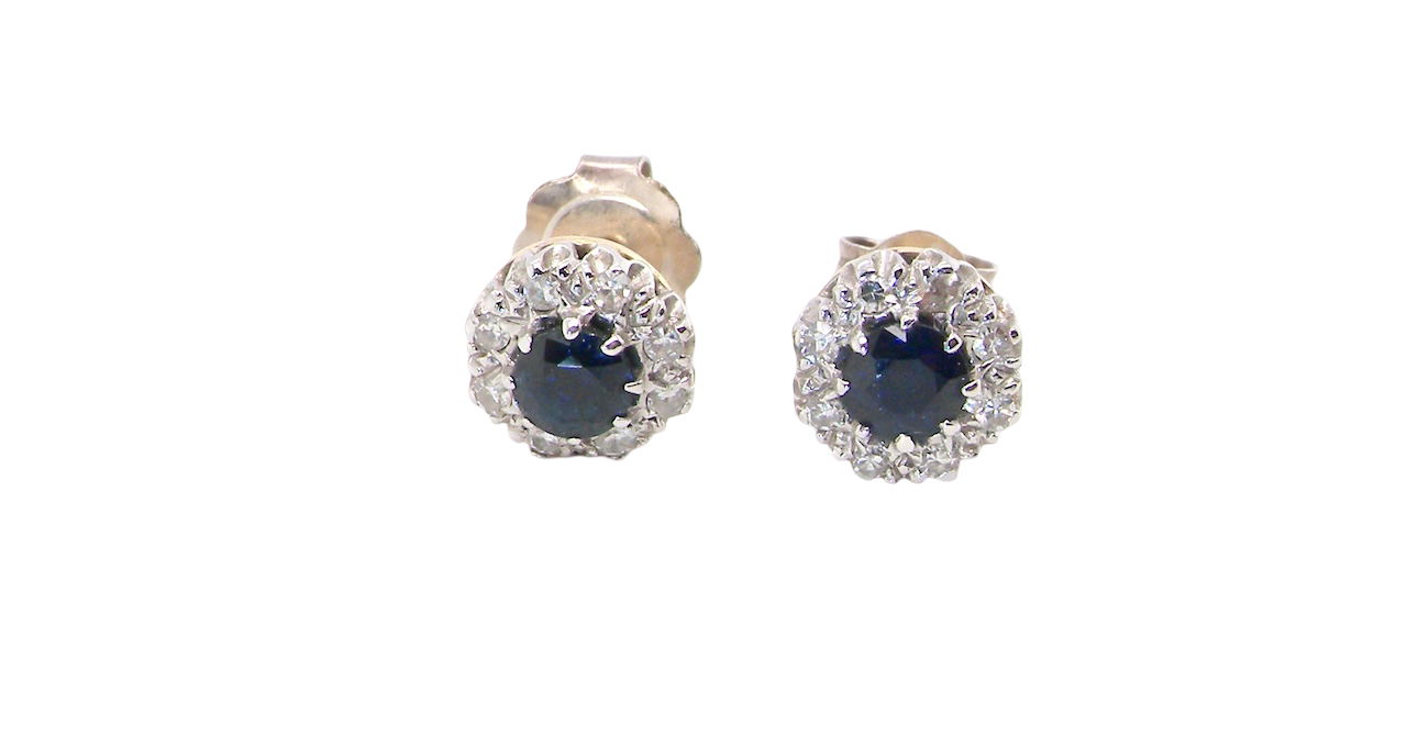 A pair of stud cluster earrings. Each earring is set with a dark blue sapphire centre .
Measures 4mm, surrounded by an outer halo of eight 1.3mm diamonds