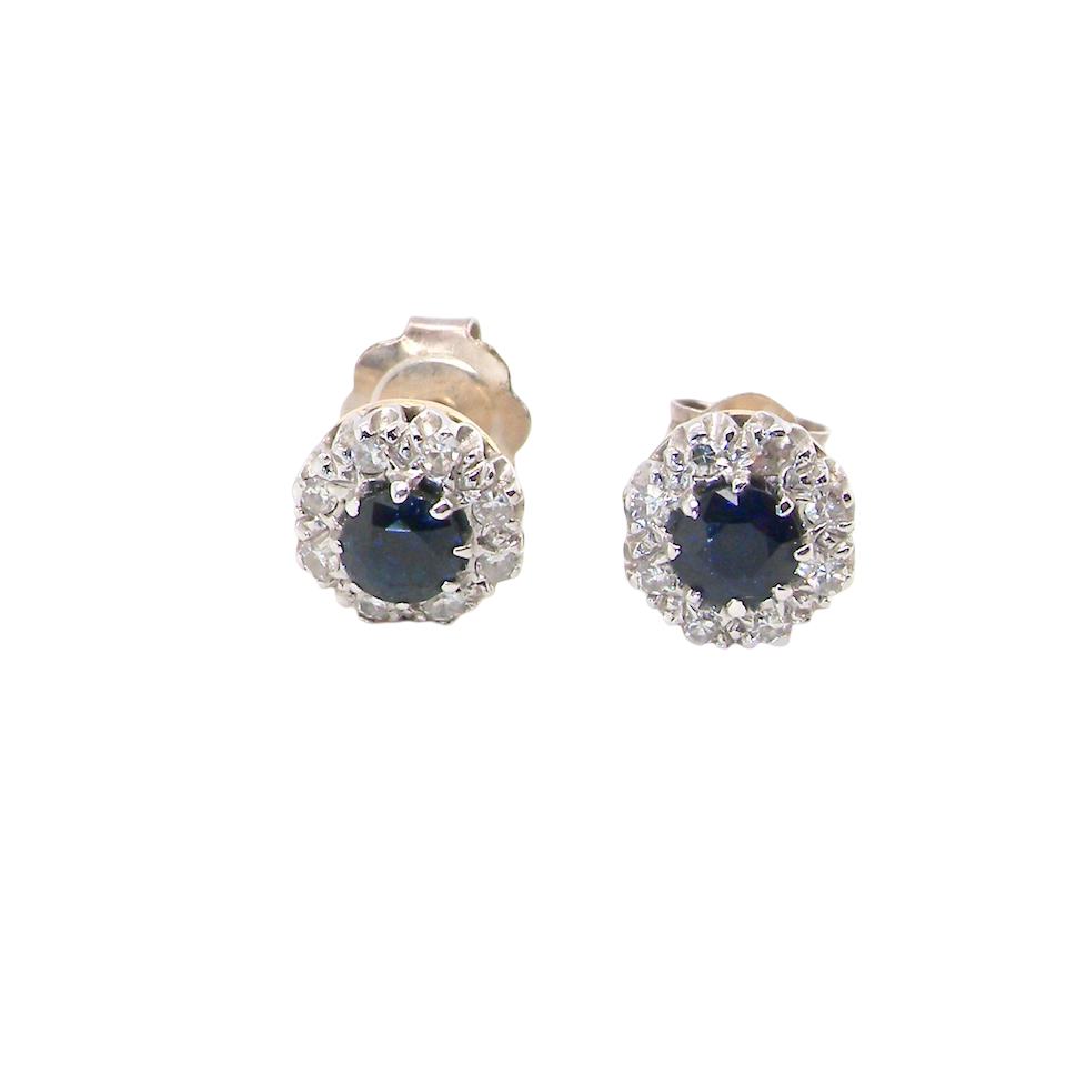A pair of stud cluster earrings. Each earring is set with a dark blue sapphire centre .
Measures 4mm, surrounded by an outer halo of eight 1.3mm diamonds