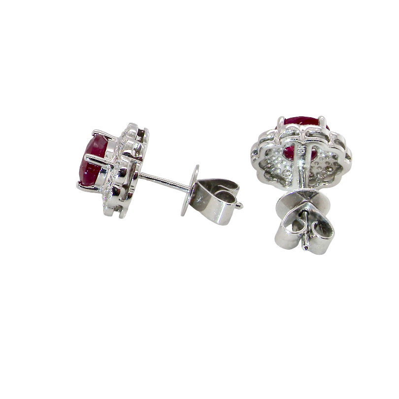 side A pair of white gold earrings, each set with an oval ruby 6x4.9mm (est 0.60 carats) complimented by an outer halo of ten 1.5mm diamonds
