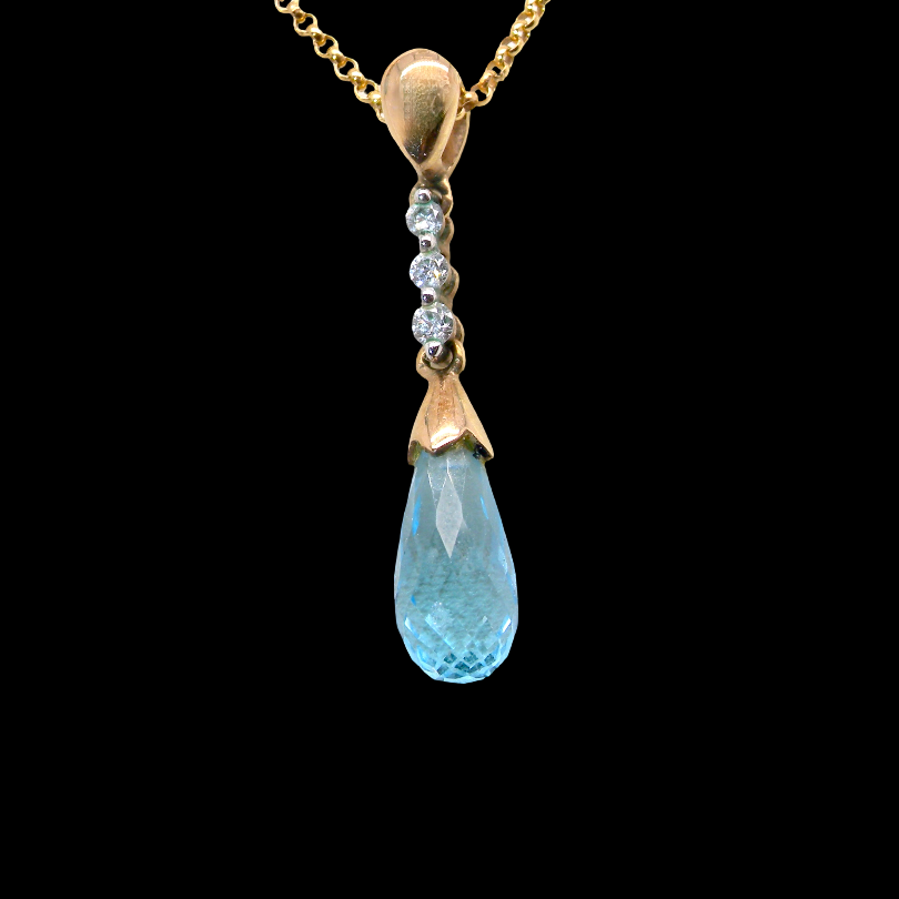 A pendant and earring set. The pendant has a pear shaped facet cut blue topaz 10x5mm. Above this three brilliant cut white cubic zirconia stones ,mm.