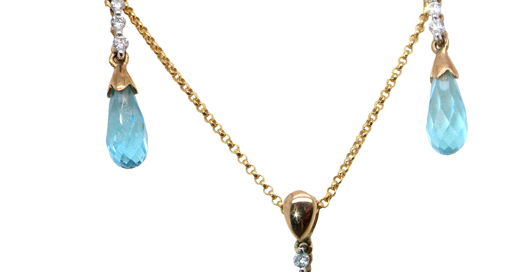 A pendant and earring set. The pendant has a pear shaped facet cut blue topaz 10x5mm. Above this three brilliant cut cubic zirconia stones ,length 20mm.
