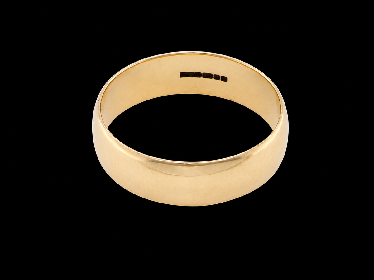 A classic yellow gold band ring with a smooth, polished finish, shown from a top-down perspective against a solid black background.