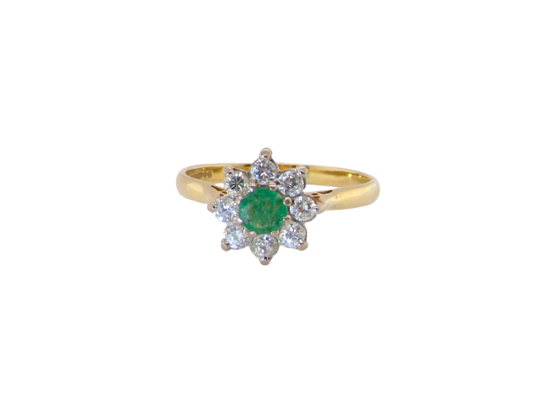 An emerald and diamond cluster ring