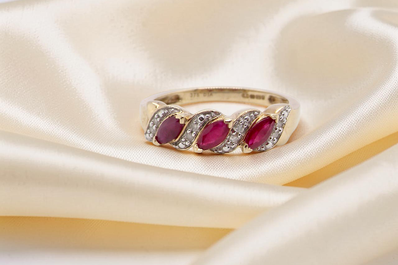 A pretty 9 carat gold dress ring. The three rubies are marquise cut, and set at an angle .