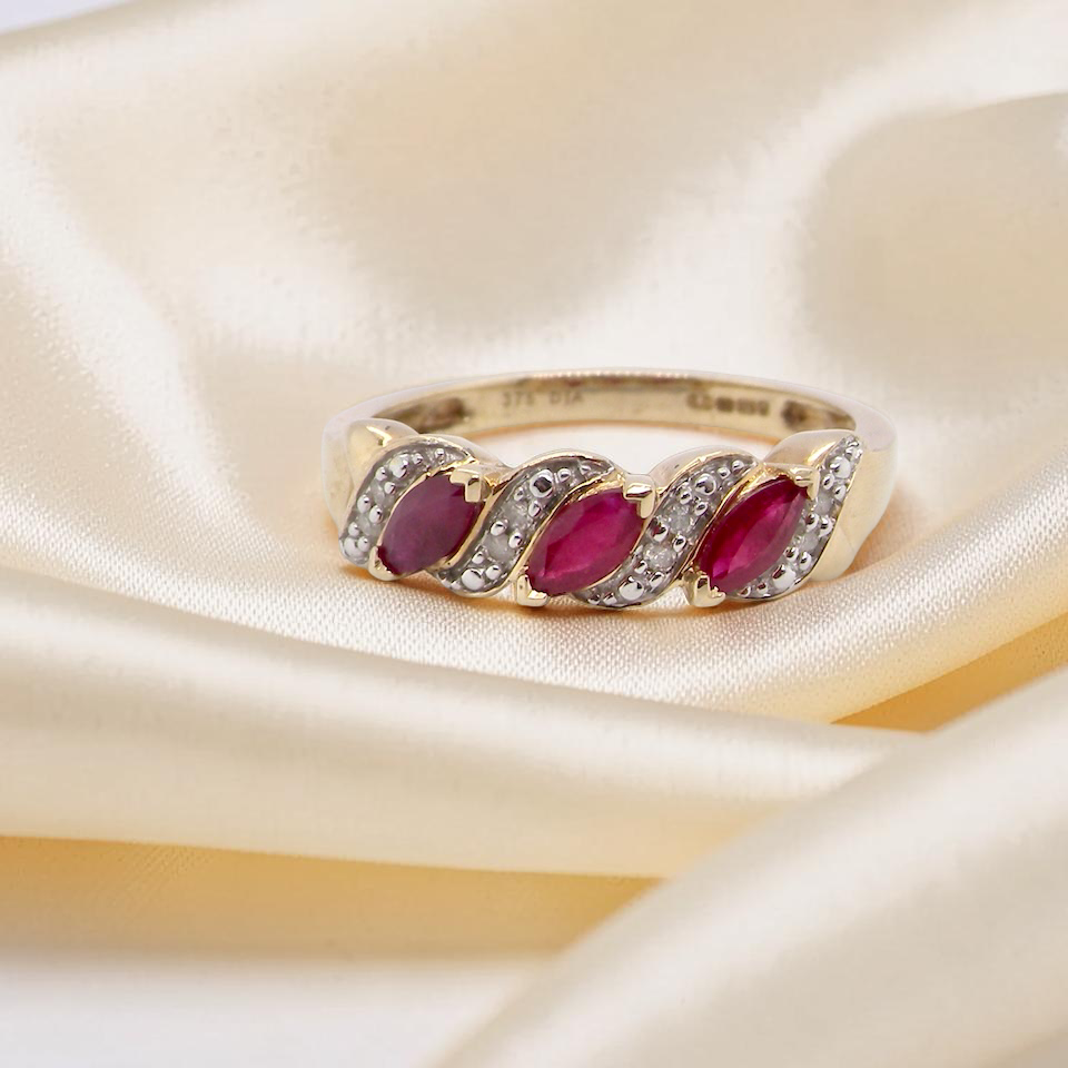 A pretty 9 carat gold dress ring. The three rubies are marquise cut, and set at an angle .