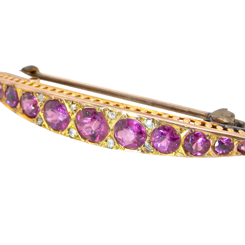 A pretty Victorian crescent shaped brooch. The principal stones are garnets