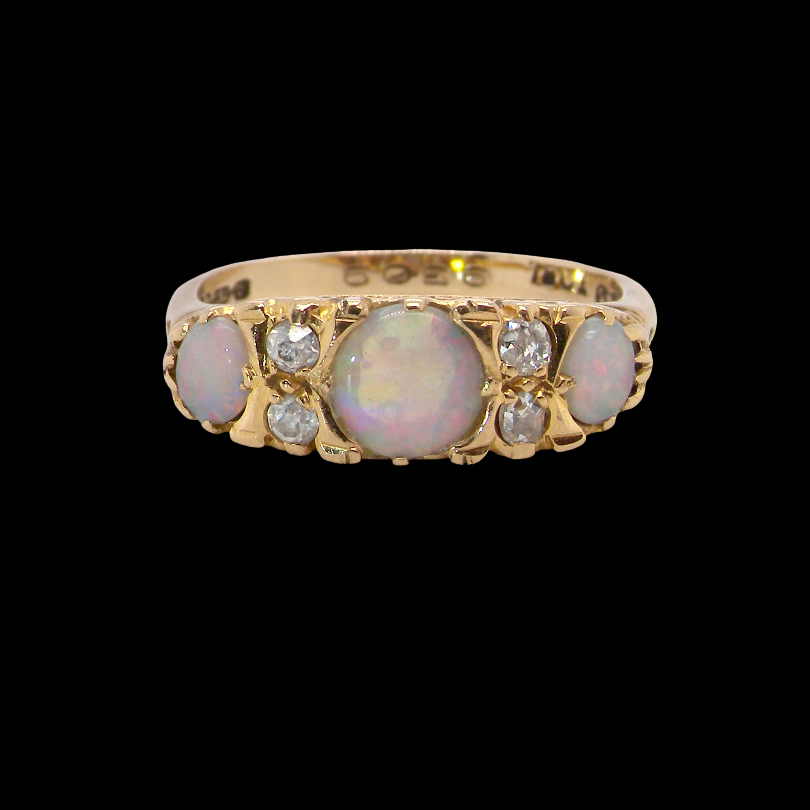 A pretty Victorian style ring. 18 carat gold. There are three opals, centre 6mm, each end 4x3mm.