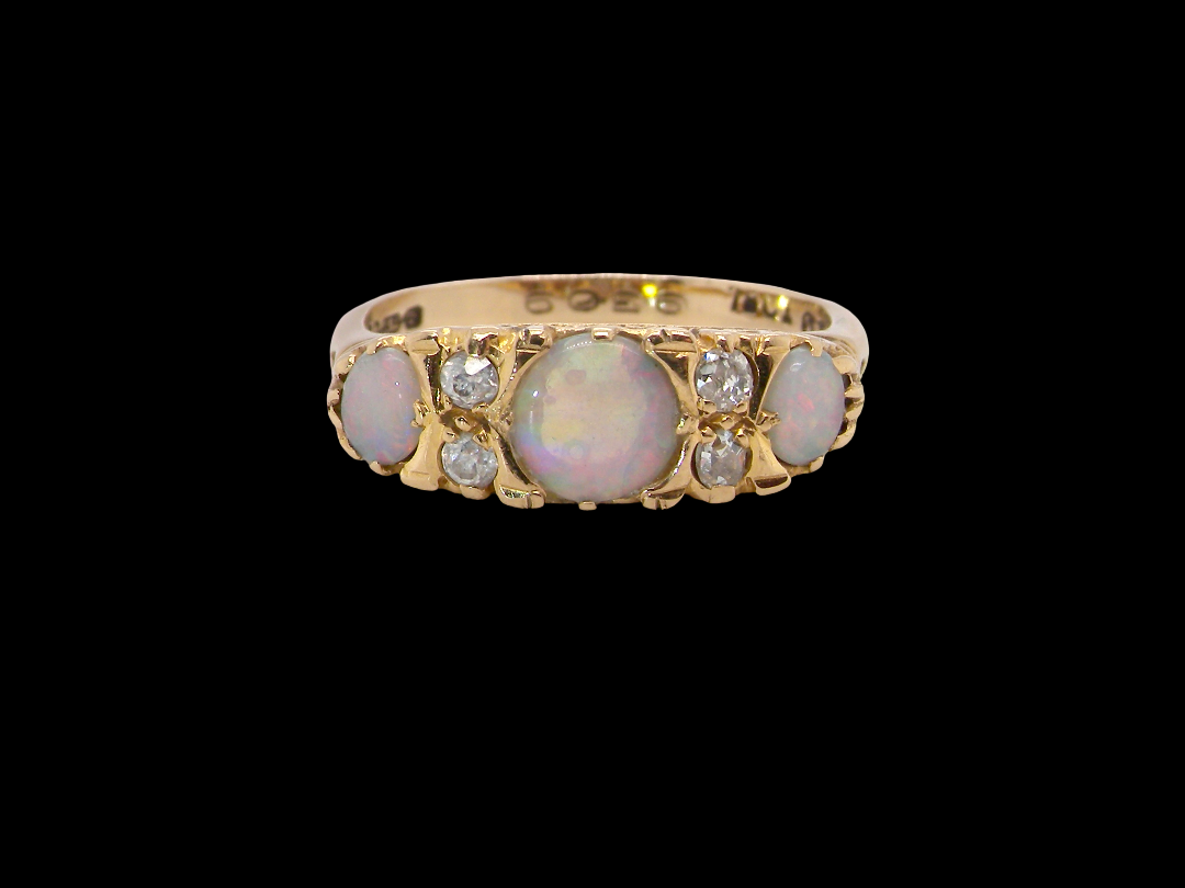 A pretty Victorian style ring. 18 carat gold. There are three opals, centre 6mm, each end 4x3mm.