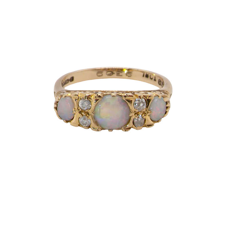 A pretty Victorian style ring. 18 carat gold. There are three opals, centre 6mm, each end 4x3mm. Good colour play