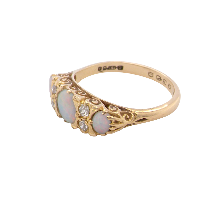 A pretty Victorian style ring. 18 carat gold. There are three opals, centre 6mm, each end 4x3mm. Good colour play side