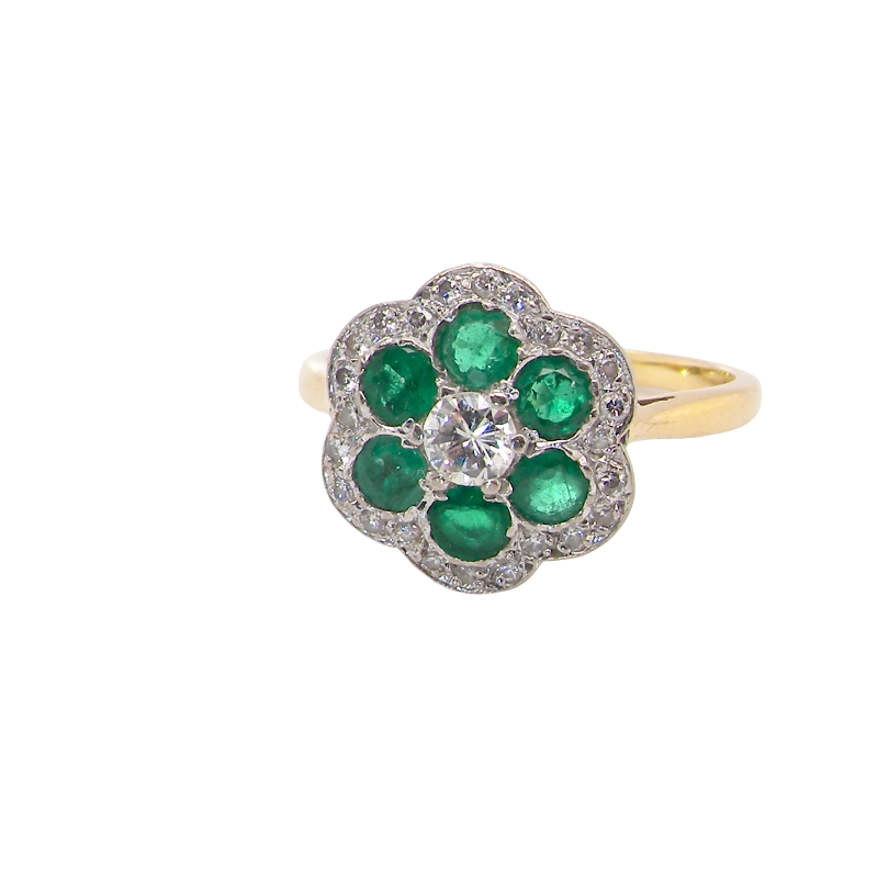 A pretty cluster ring. Features emeralds and diamonds. Centre stone a brilliant cut white diamond, measures 4mm