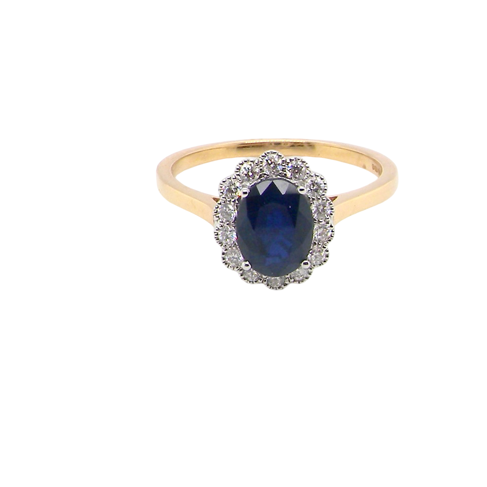 A pretty cluster ring that features an inky black blue sapphire that measures 8x6mm. Complimented by an outer border of 2mm diamonds