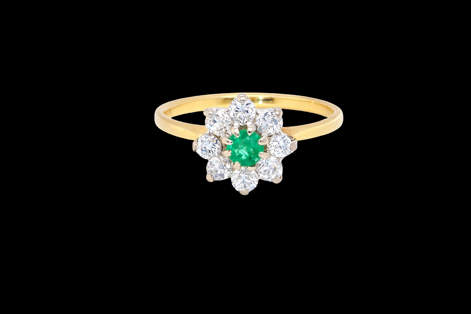 A pretty cluster ring that features to the centre a round emerald with diamonds