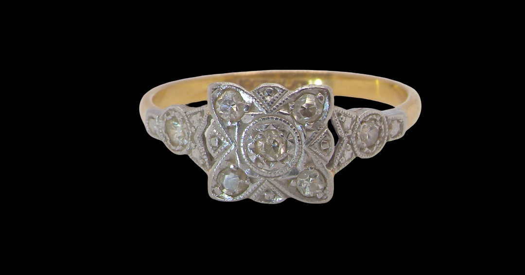 A pretty diamond cluster ring from the early part of the 20th century. A square head that has within it small white diamonds, measures 8x8mm, fancy shoulders
