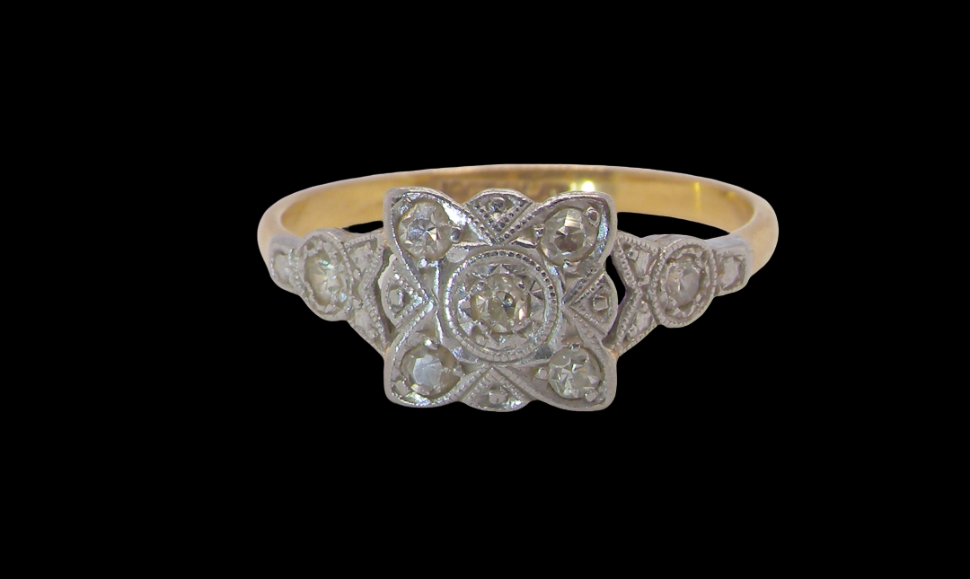 A pretty diamond cluster ring from the early part of the 20th century. A square head that has within it small white diamonds, measures 8x8mm, fancy shoulders