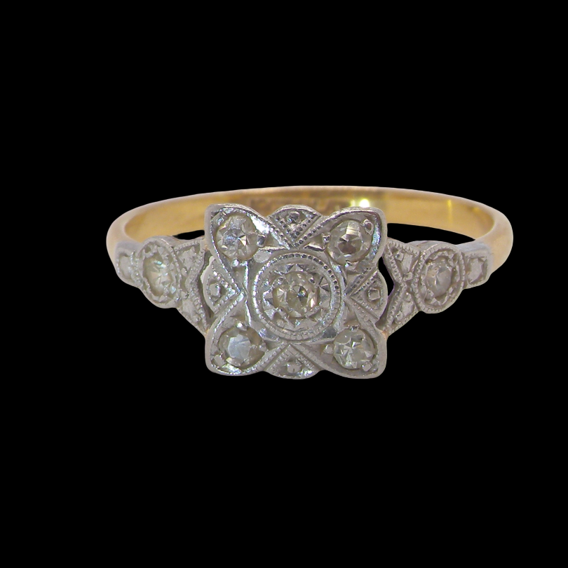 A pretty diamond cluster ring from the early part of the 20th century. A square head that has within it small white diamonds, measures 8x8mm, fancy shoulders
