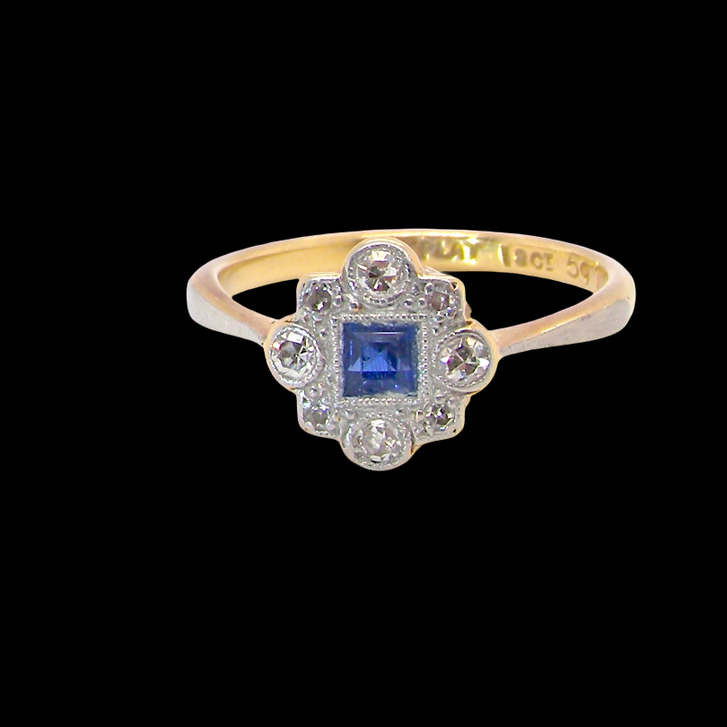 A pretty early 20th century cluster ring. The centre stone a square mid blue sapphire, mille grain setting. 