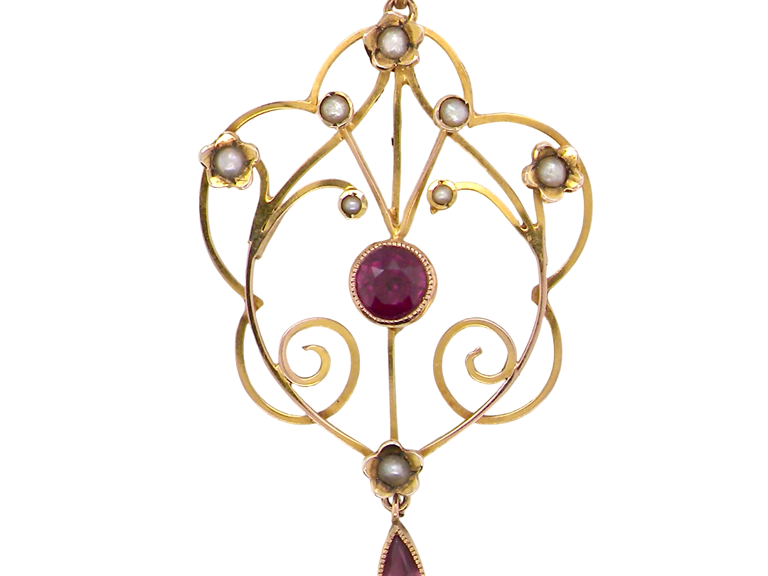 A pretty early 20th century pendant. Openwork design with a round garnet to the centre, measures 5.6mm,