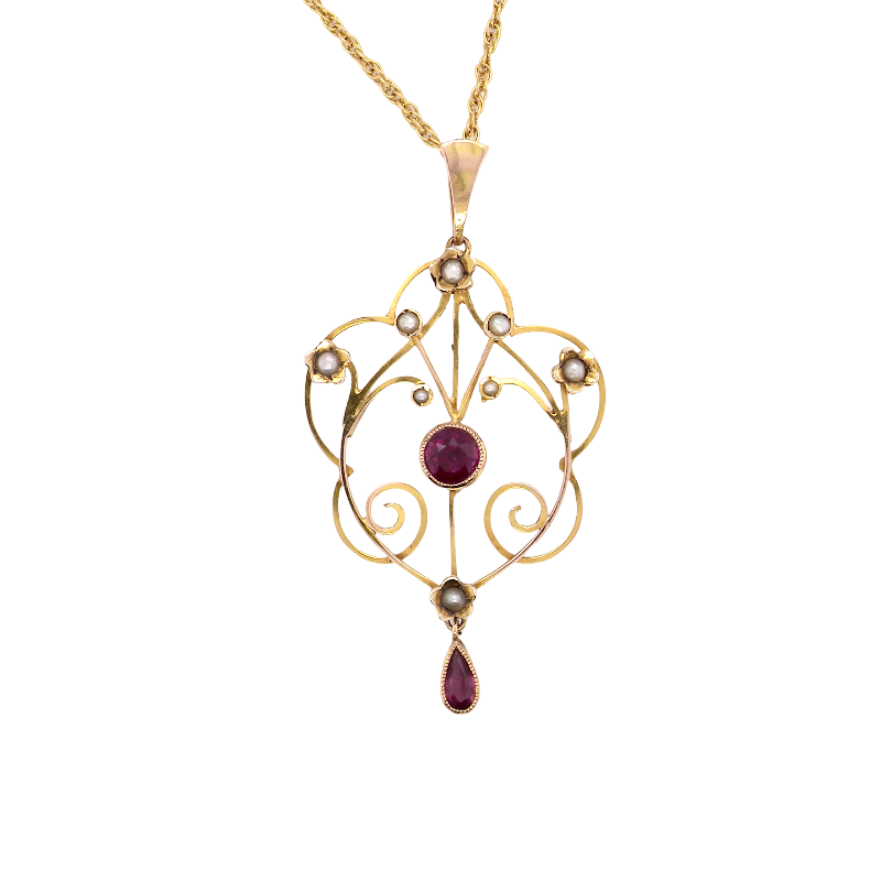 A pretty early 20th century pendant. Openwork design with a round garnet to the centre, measures 5.6mm, mille grain setting.