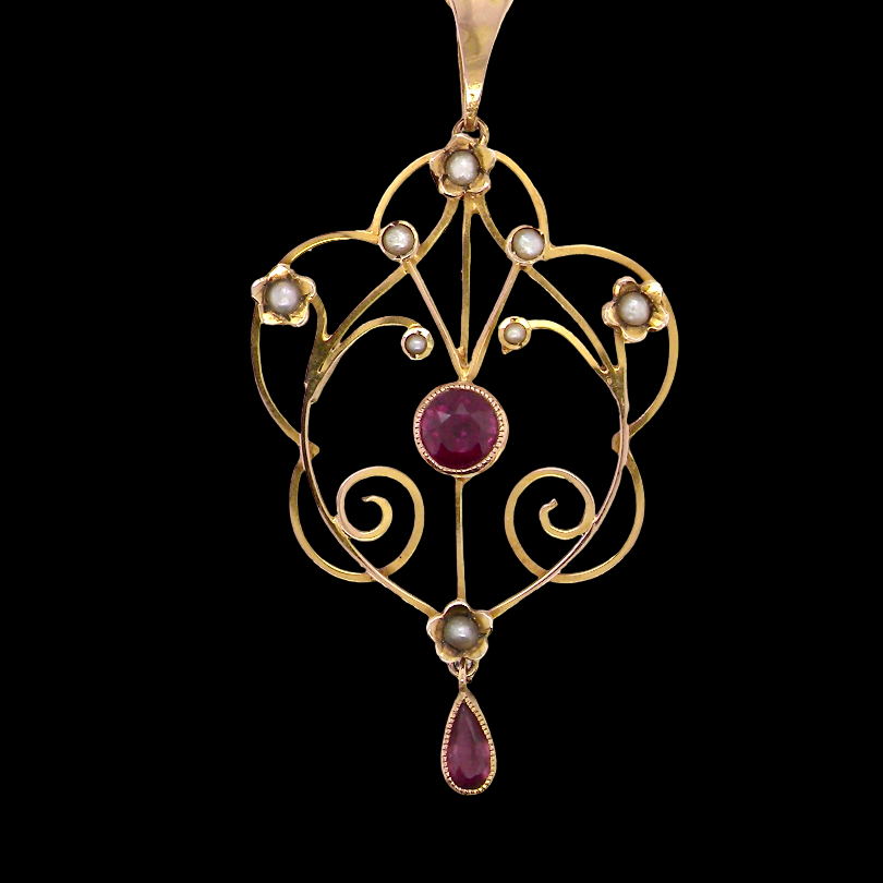 A pretty early 20th century pendant. Openwork design with a round garnet to the centre, , mille grain setting.
