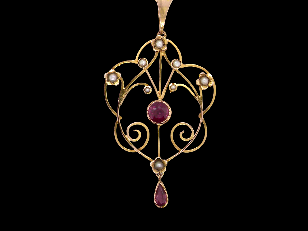 A pretty early 20th century pendant. Openwork design with a round garnet to the centre, , mille grain setting.