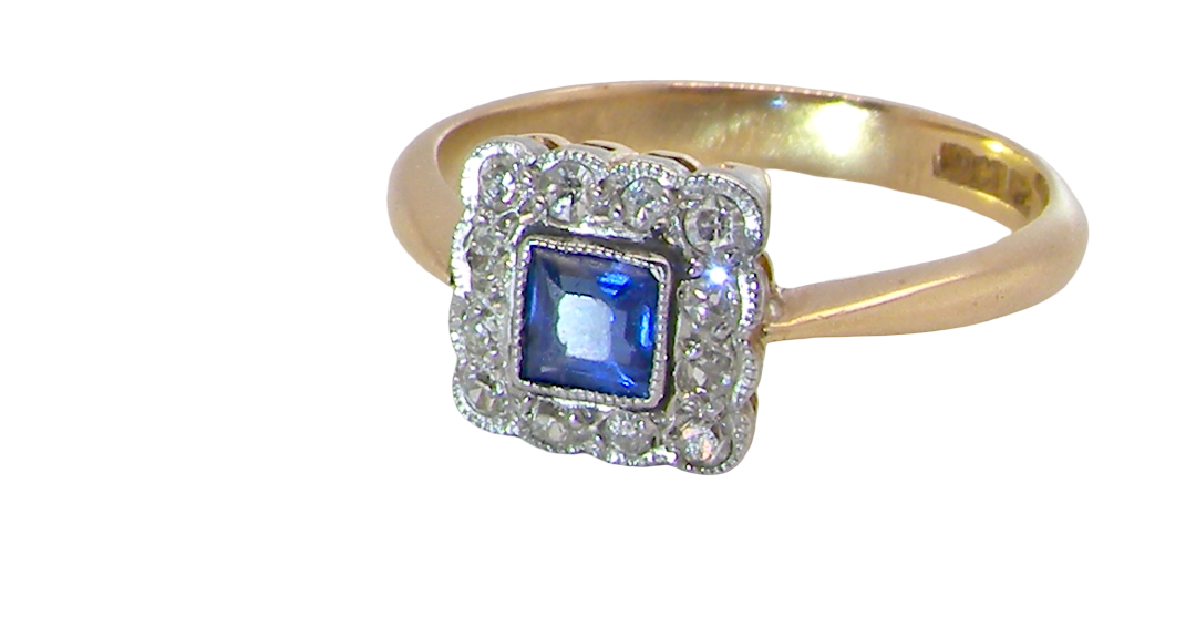 A pretty square cluster ring. Features to the centre a cornflower blue square sapphire, 4x4mm (est 0.30 carats) mille grain set.
Complimented by a halo of twelve single cut white diamonds