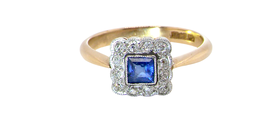 A pretty square cluster ring. Features to the centre a cornflower blue square sapphire, 4x4mm (est 0.30 carats) mille grain set.
Complimented by a halo of twelve x 1.5 mm single cut white diamonds