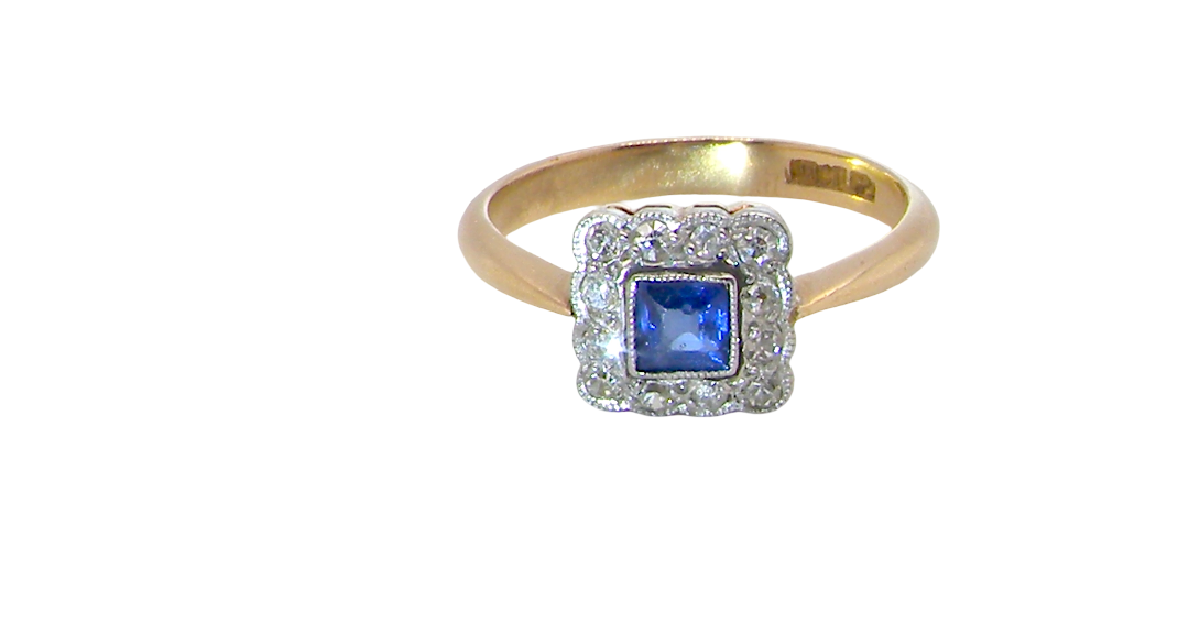 A pretty square cluster ring. Features to the centre a cornflower blue square sapphire, 4x4mm (est 0.30 carats) mille grain set.
Complimented by a halo of twelve x 1.5 mm white diamonds