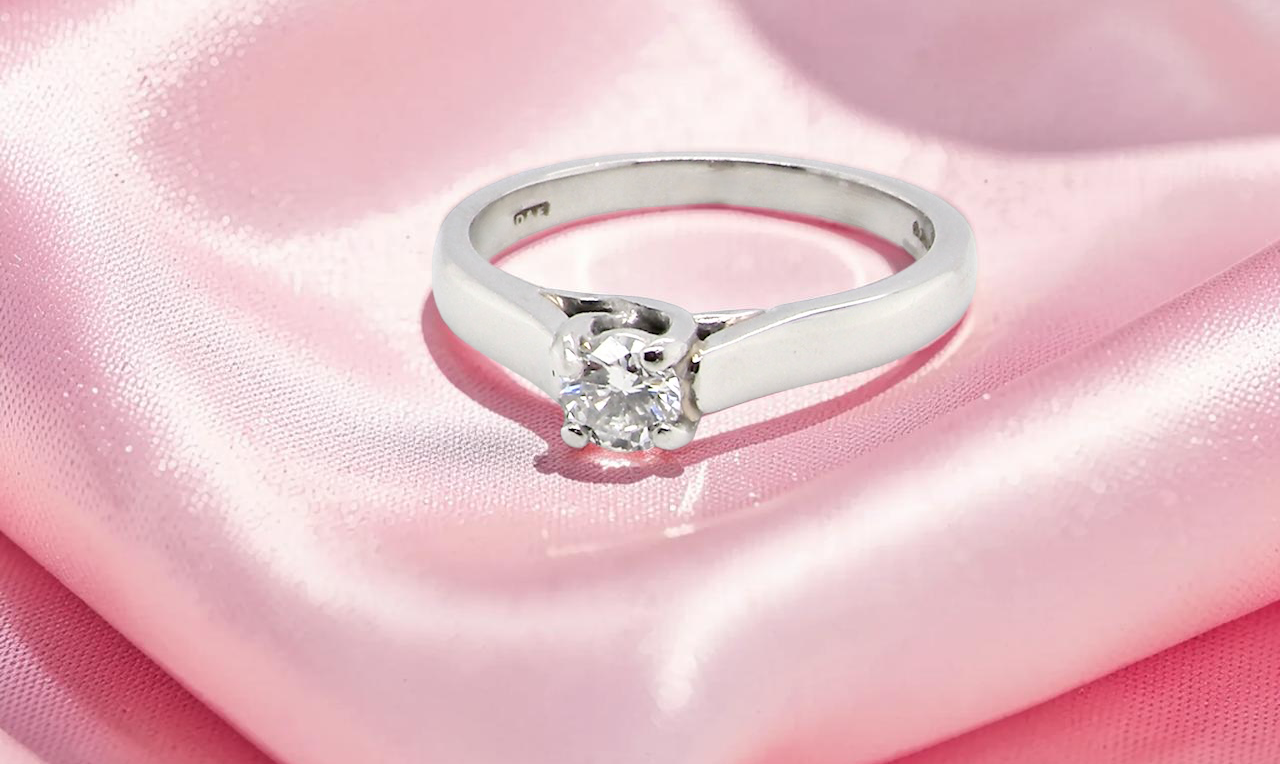 A single stone solitaire diamond ring. The modern brilliant cut white diamond measures 3.9mm (0.22 carats est)