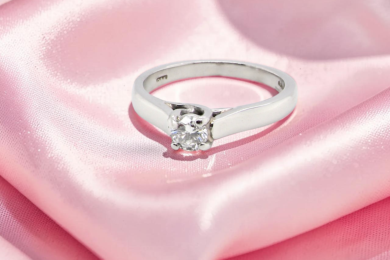 A single stone solitaire diamond ring. The modern brilliant cut white diamond measures 3.9mm (0.22 carats est)