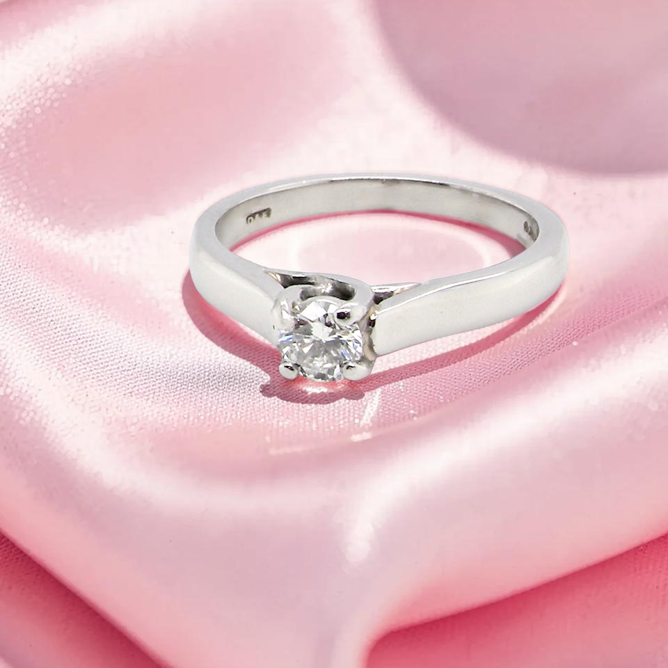 A single stone solitaire diamond ring. The modern brilliant cut white diamond measures 3.9mm (0.22 carats est)