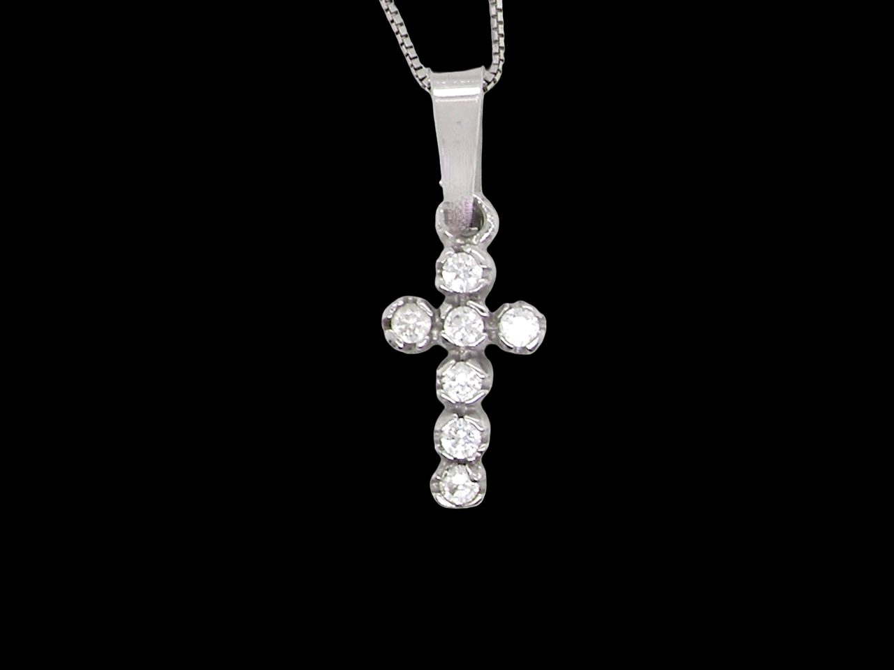 A small cross pendant in 18 carat white gold, set with 7 brilliant-cut white diamonds.