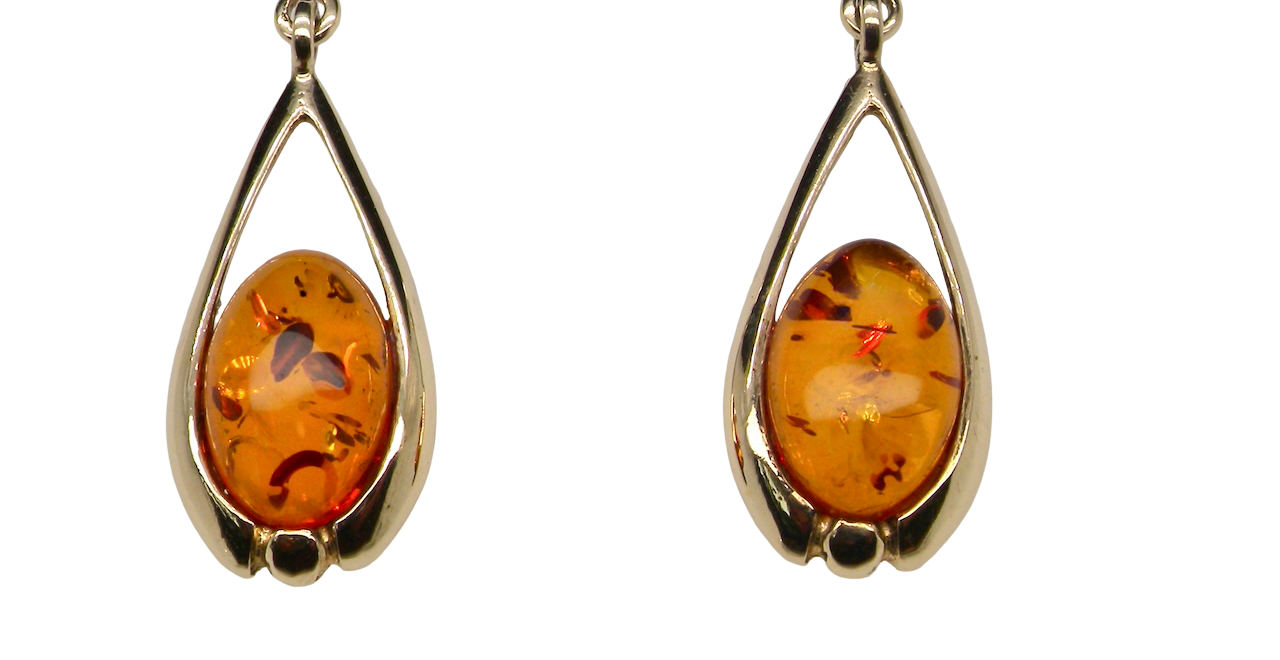 A smart pair of drop earrings, each containing an oval amber stone,