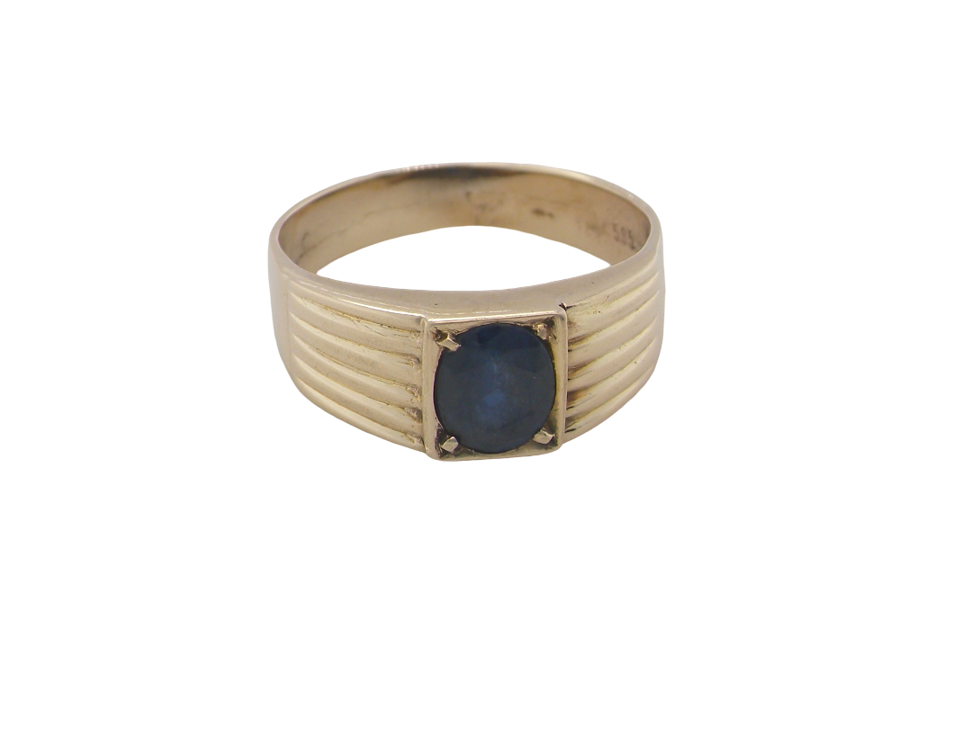 A solitaire dress ring that features an oval cut dark blue sapphire, 6x5mm. Wide ribbed patterned shoulders, 7mm width and tapering to a 3.8mm shank at the reverse.