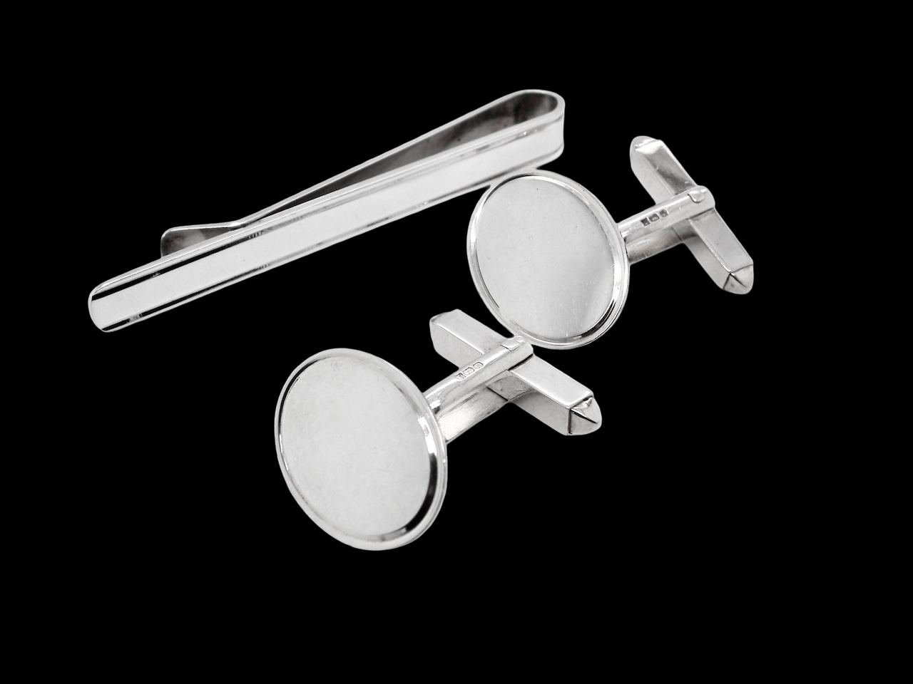A sterling silver set. Consisting of a pair of plain oval shaped cufflinks. Head 17x13mm, torpedo fittings. Hallmarks for 1994.