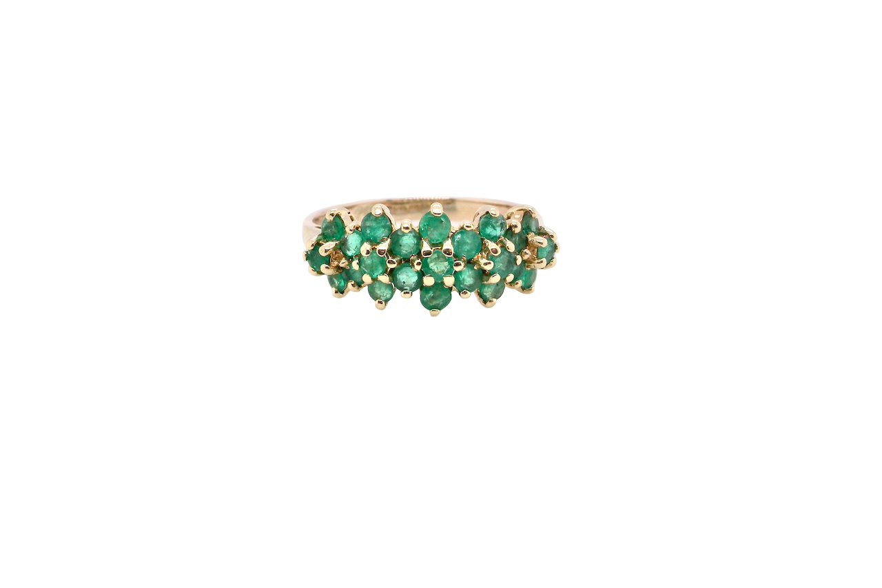 A striking and unusual dress ring, designed with multiple clusters of round-cut emeralds set beautifully across the finger for a bold, eye-catching look.