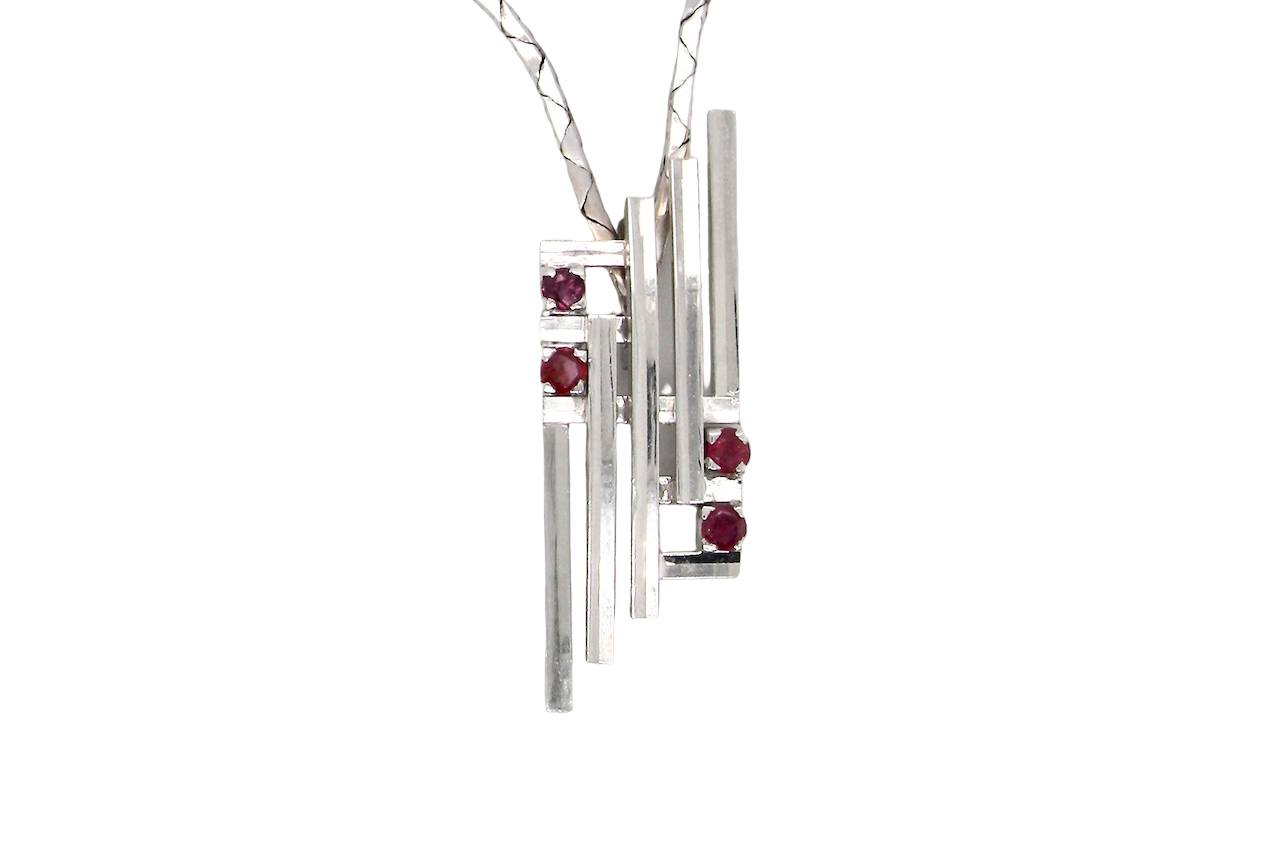 A striking modern pendant set with four 3mm rubies. The pendant measures approximately 40mm x 14mm and features a sleek design of five horizontal bars, with the outer bars