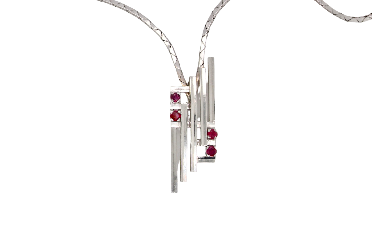 A striking modern pendant set with four 3mm rubies. The pendant measures approximately 40mm x 14mm and features a sleek design of five horizontal bars, with the outer bars each set with vibrant round rubies.