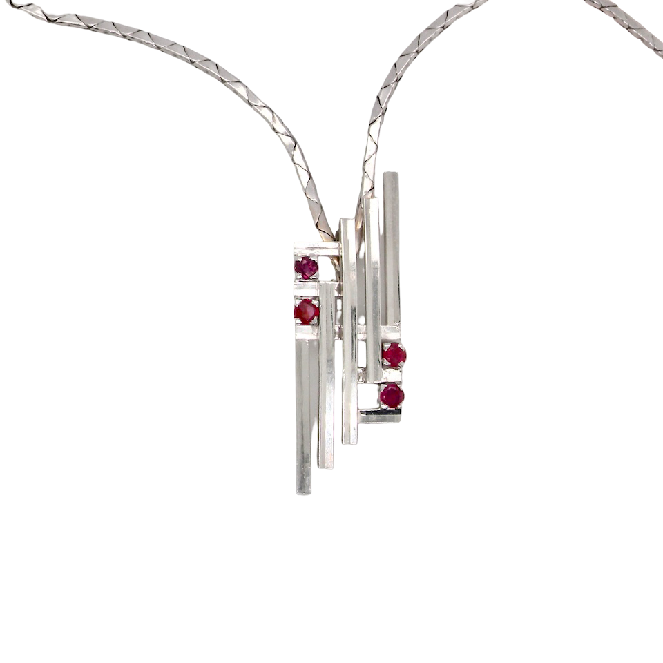 A striking modern pendant set with four 3mm rubies. The pendant measures approximately 40mm x 14mm and features a sleek design of five horizontal bars, with the outer bars each set with vibrant round rubies.
