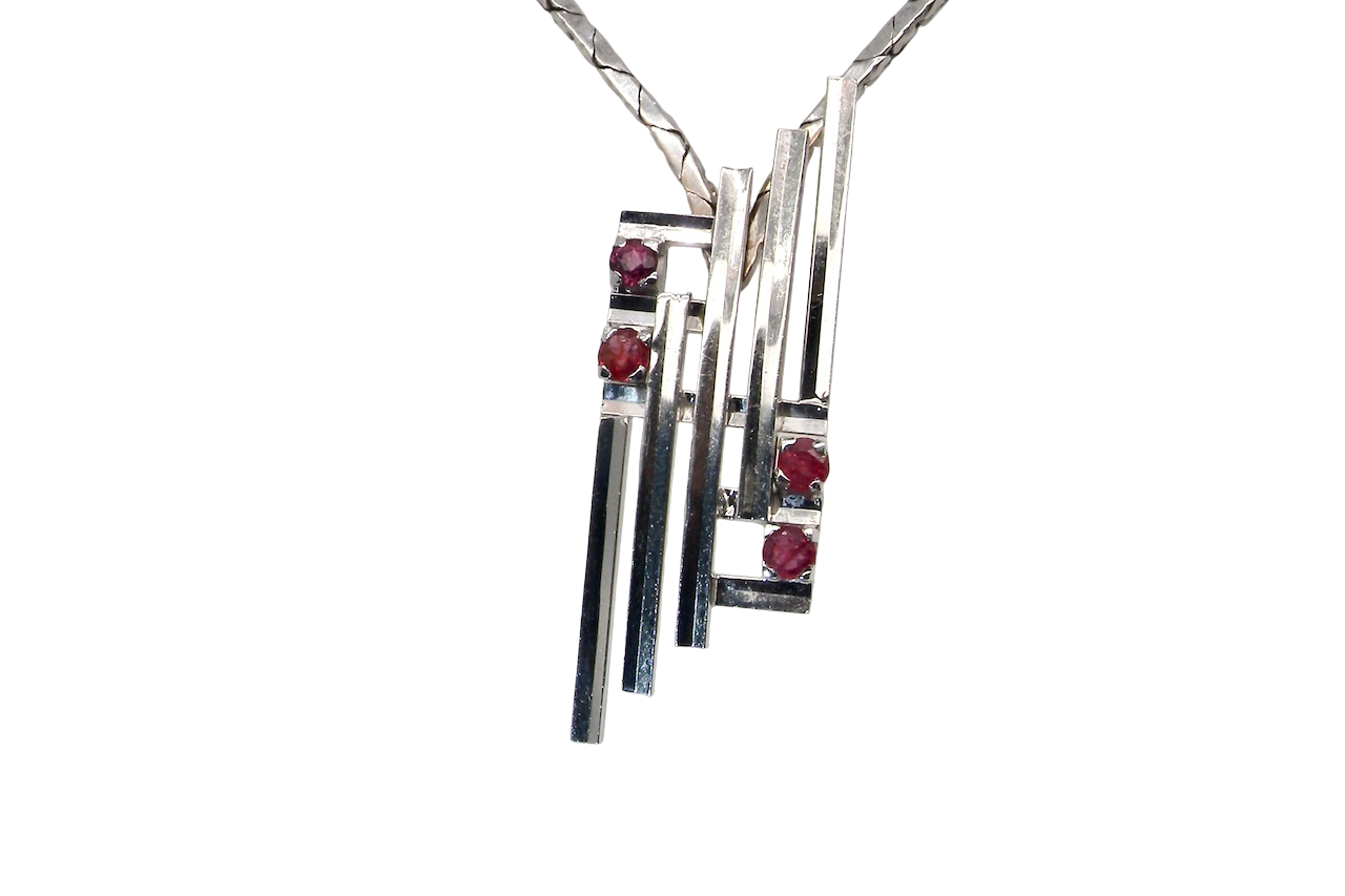 A striking modern pendant set with four 3mm rubies. The pendant measures approximately 40mm x 14mm and features a sleek design of horizontal bars, with the outer bars each set with vibrant round rubies.