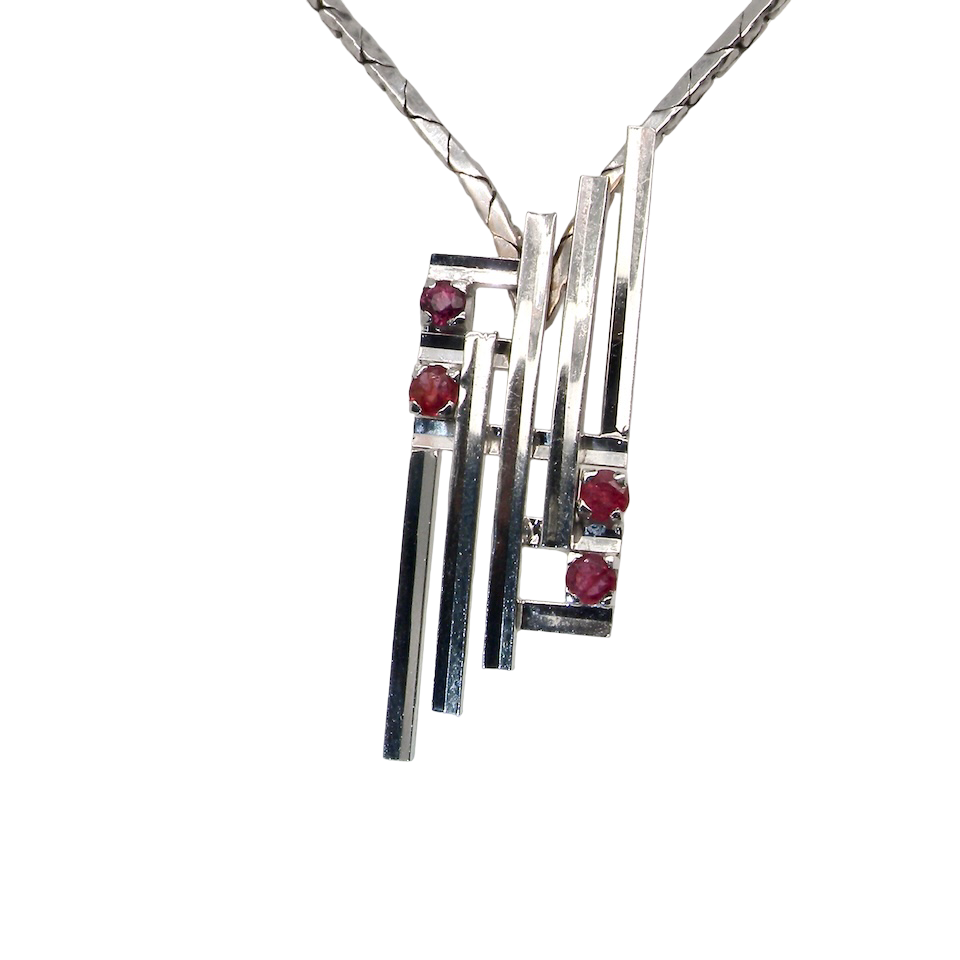 A striking modern pendant set with four 3mm rubies. The pendant measures approximately 40mm x 14mm and features a sleek design of horizontal bars, with the outer bars each set with vibrant round rubies.