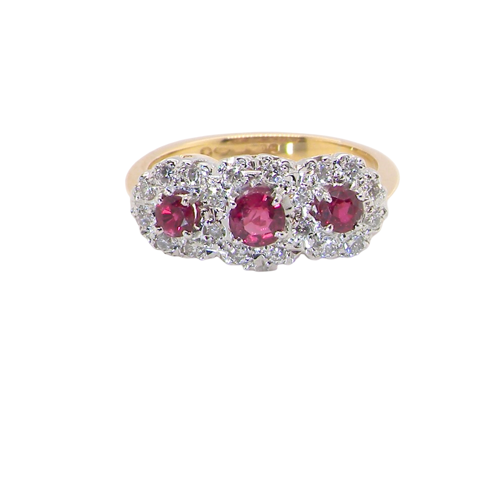 A striking triple cluster ring crafted in 18 carat gold, dating circa 1990–2000, and fully hallmarked in the UK.
✨ Design & Gemstones
Three deep red rubies set to the centre of each cluster