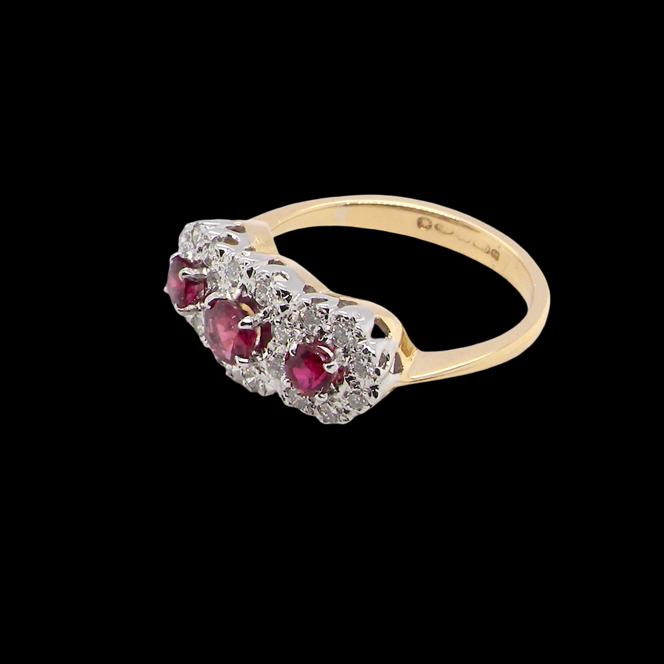 A striking triple cluster ring crafted in 18 carat gold, dating circa 1990–2000, and fully hallmarked in the UK.
✨ Design & Gemstones
red rubies set to the centre of each cluster
