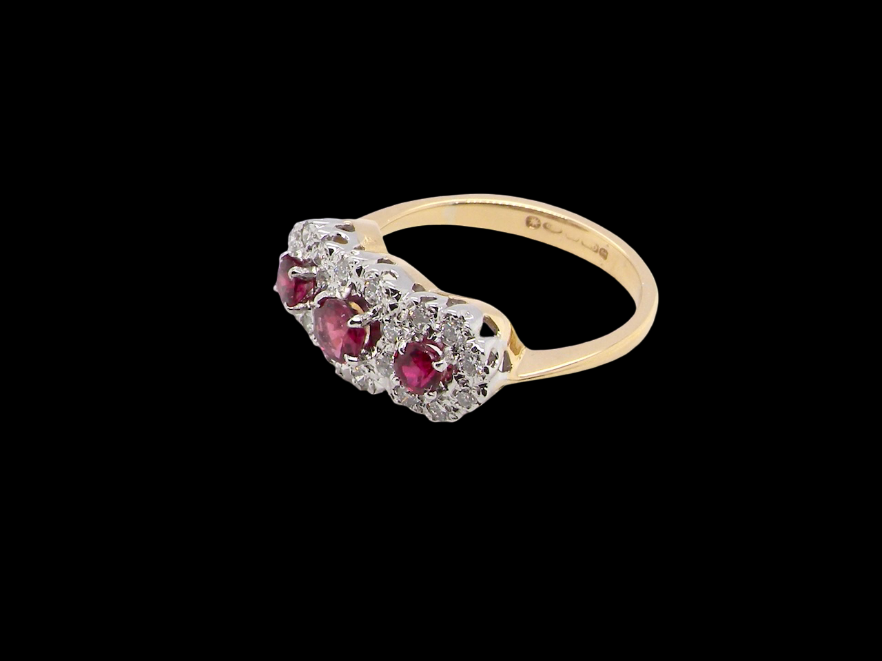 A striking triple cluster ring crafted in 18 carat gold, dating circa 1990–2000, and fully hallmarked in the UK.
✨ Design & Gemstones
red rubies set to the centre of each cluster