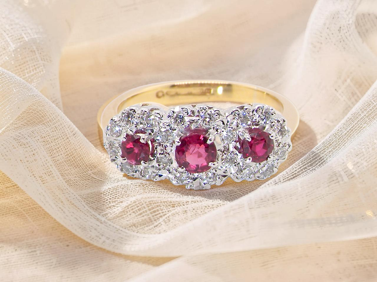 A striking triple cluster ring crafted in 18 carat gold, dating circa 1990–2000, and fully hallmarked in the UK.